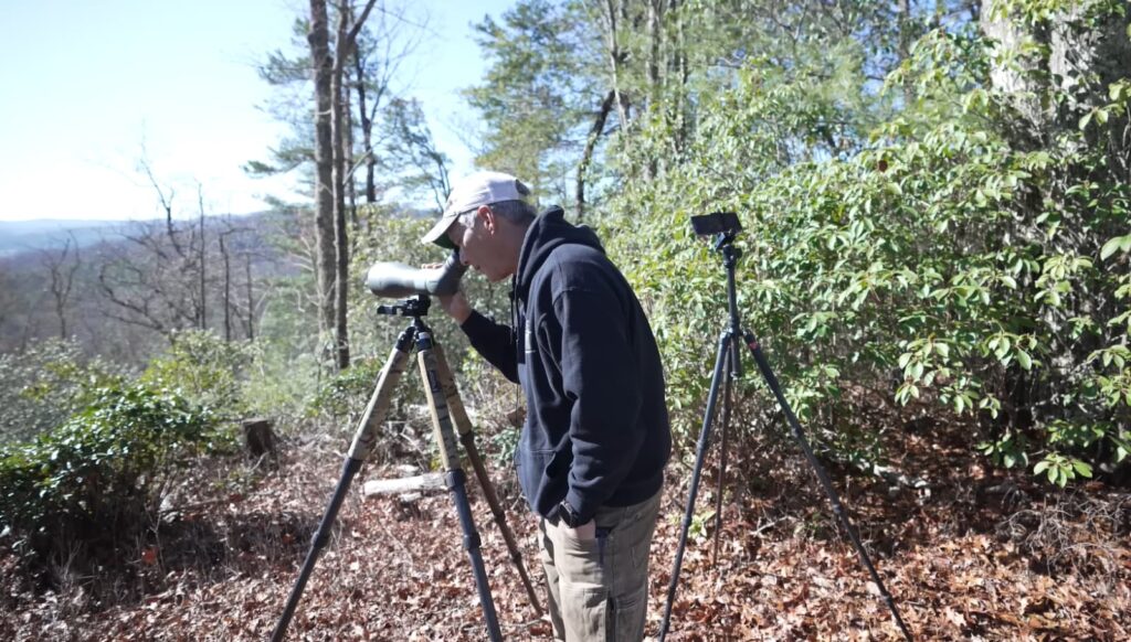 a man looking through the scope